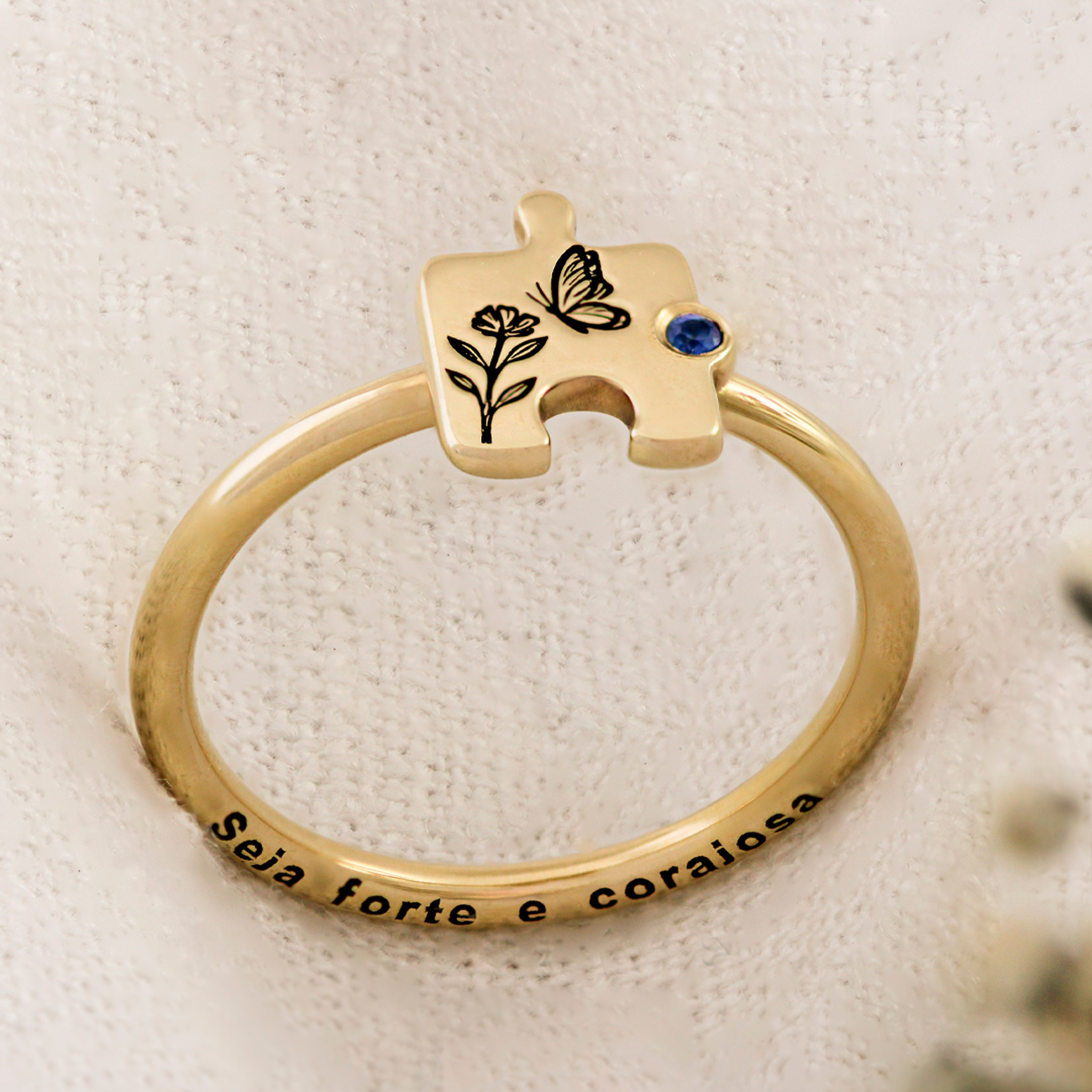 anel-personalizado-em-ouro-18k-com-quebra-cabeca-e-safira-azul-e-borboleta-para-autismo-e-mae-de-autistas-em-tecido